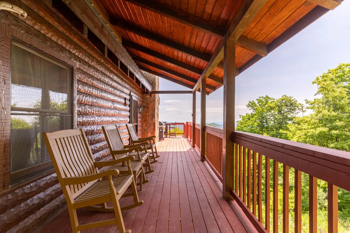 This image features a serene porch with classic wooden rocking chairs overlooking a scenic mountain view. The inviting setting is perfect for relaxing after outdoor adventures or enjoying quiet moments with your pet.